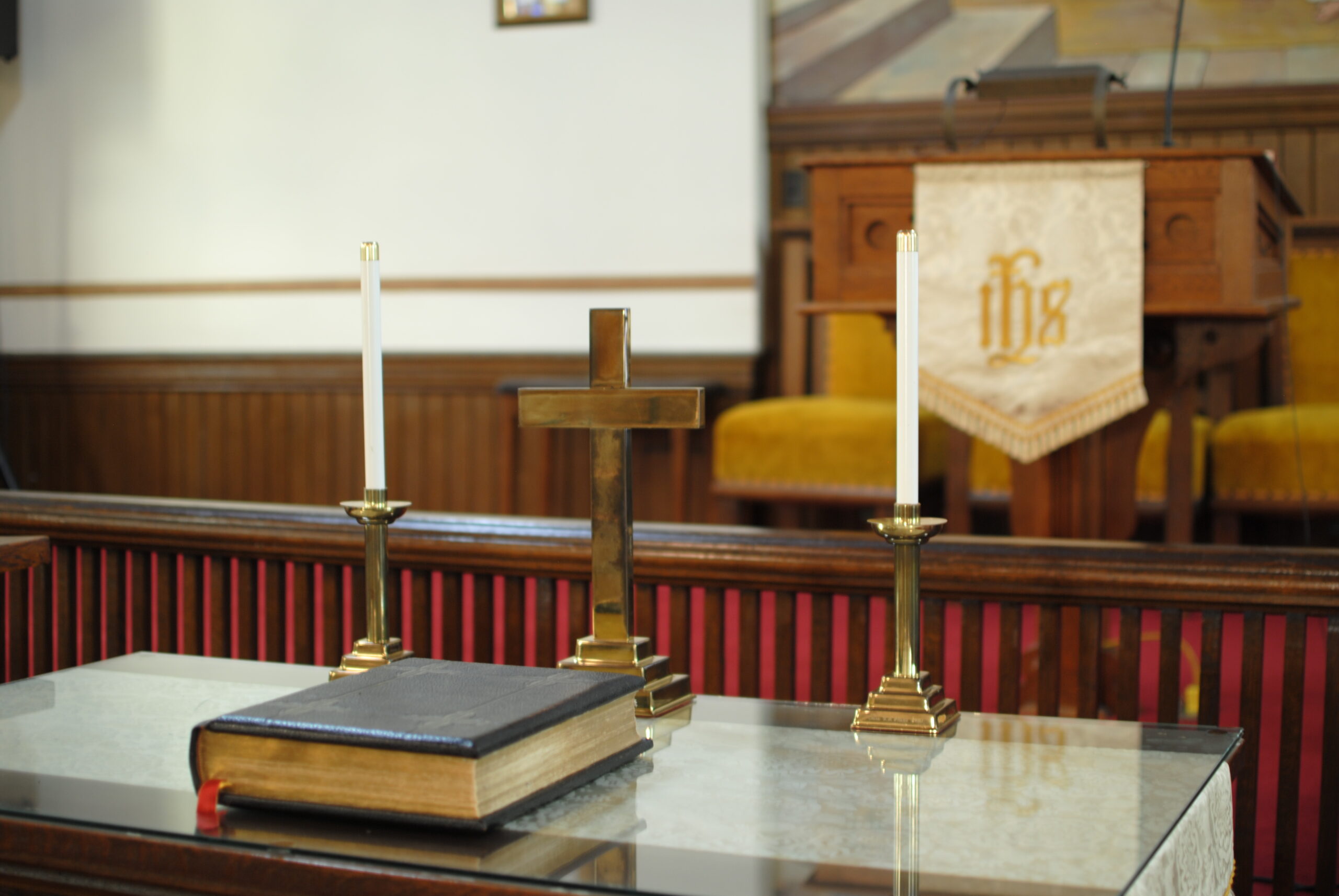 Bible on altar with candle sticks and cross