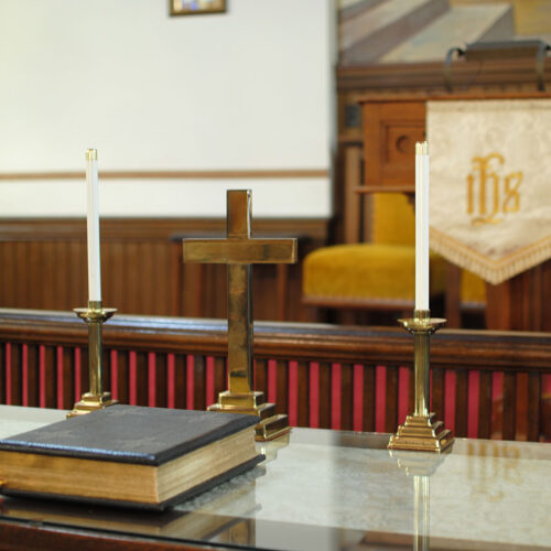 Bible on altar with candle sticks and cross