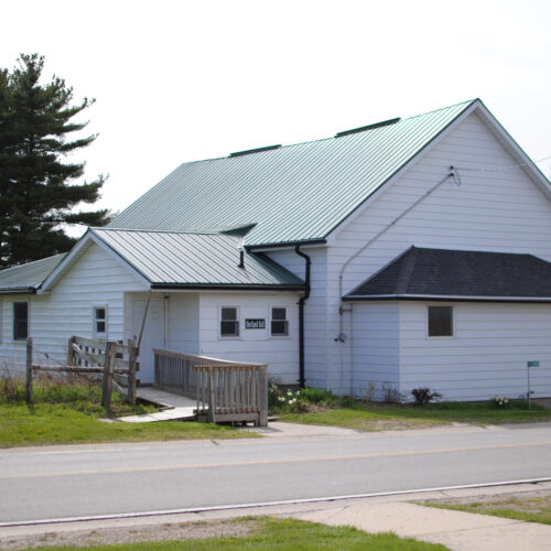 The ministries hall with white siding and green roof