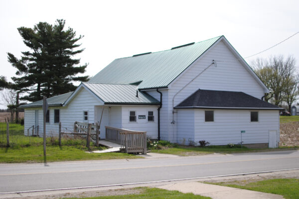 The ministries hall with white siding and green roof