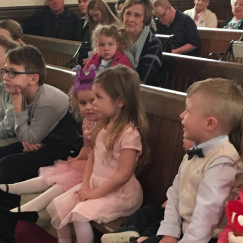 Children sitting in front row church pew