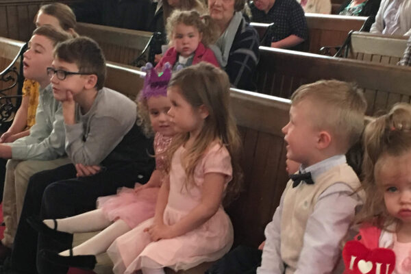 Children sitting in front row church pew