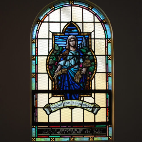 Stained glass window depicting Ruth holding a sheaf of wheat